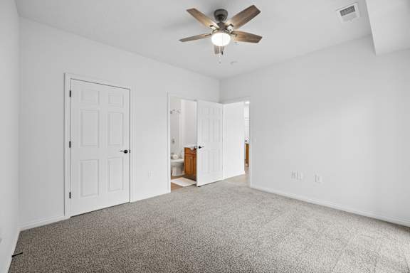A room with a ceiling fan and carpeted floor.