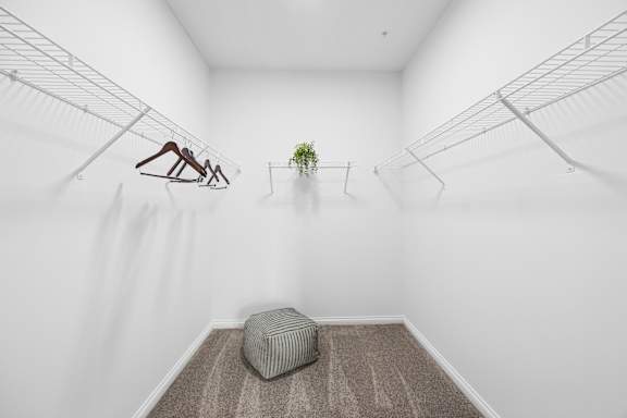A room with a hanging sculpture, a potted plant, and a bench.