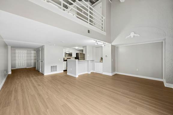 A large empty room with wooden floors and white walls.