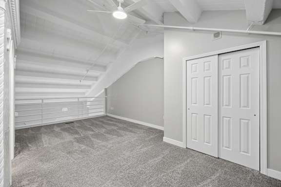A room with a carpeted floor and a white door.