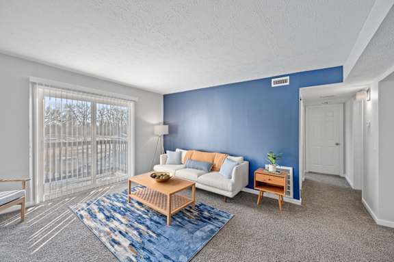 A living room with a blue wall and a white couch.