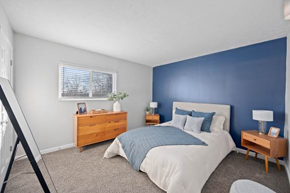 A bedroom with a bed, nightstands, and a dresser.
