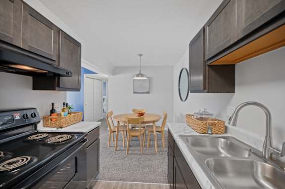 A kitchen with a dining table and chairs in the middle.