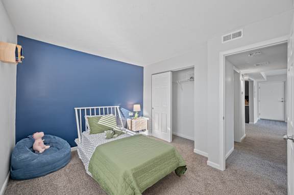 A bedroom with a white bed and a blue wall.