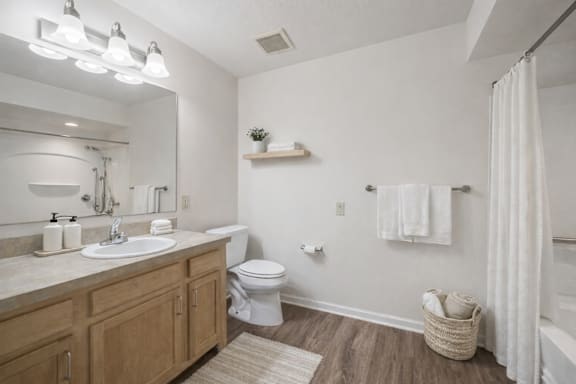 A bathroom with a white sink, toilet, and a white shower curtain.