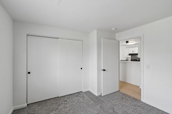A white door with a black handle is in a room with white walls.