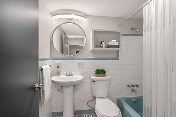 a small bathroom with a white sink and toilet and a blue bathtub at Cincinnati Premier Living*, Cincinnati, Ohio