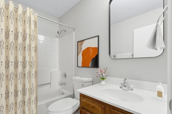 A bathroom with a toilet, sink, and shower.