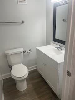 A white toilet sits next to a sink in a small bathroom.