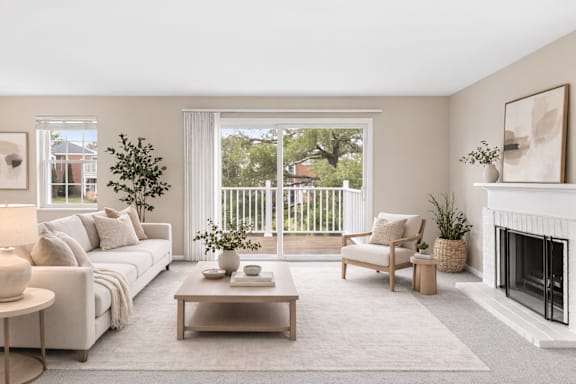 A living room with a white couch, a coffee table, a chair, a fireplace, and a painting on the wall.