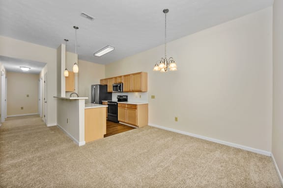 a spacious living room with a kitchen and a carpeted floor at Bishops Gate, Cincinnati
