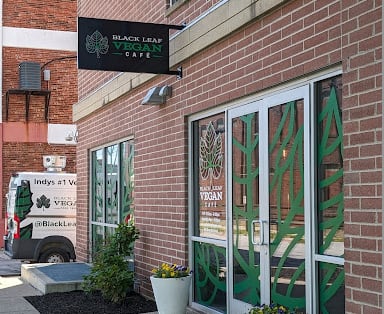 A brick building with a sign that says Black Leaf Vegan Cafe.