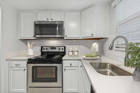 A modern kitchen with a stove, oven, microwave, and sink.