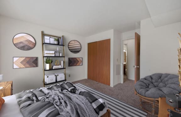 a bedroom with a bed and a chair in a 555 waverly unit at The Woodridge Collection, Ohio, 45014