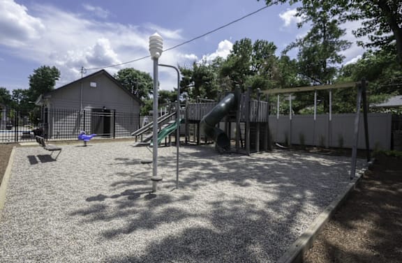 a playground with a slide and swings at Olde Towne in Kenwood, Cincinnati