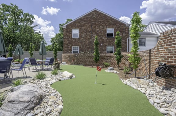 a backyard putting green with a house and patio in the background at Olde Towne in Kenwood, Ohio