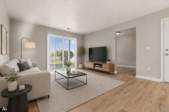A living room with a white couch, a black coffee table, and a flat screen TV.