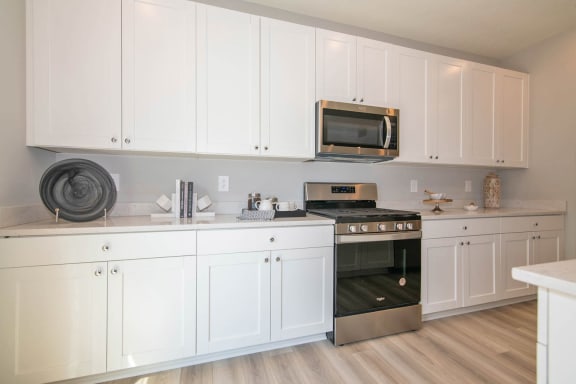 a kitchen with white cabinets and stainless steel appliances at Jackson Run Townhomes, Indiana