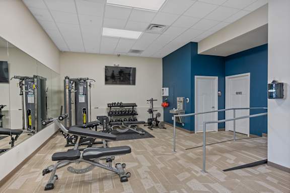 A gym with a blue wall and a mirror.