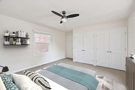 A bedroom with a bed, pillows, a ceiling fan, and a window.