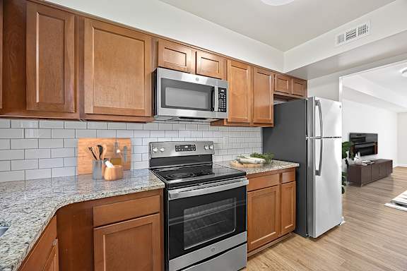 A kitchen with wooden cabinets and a black refrigerator.
