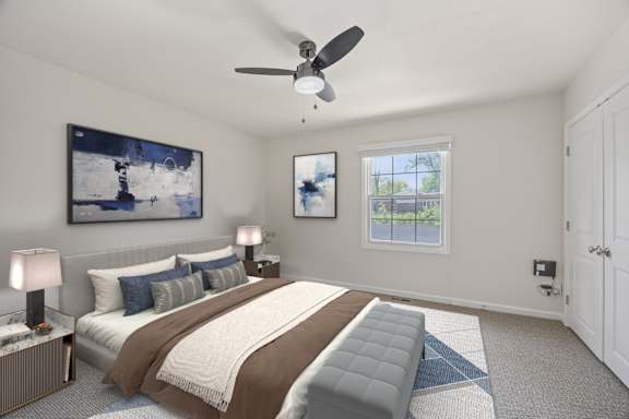 A bedroom with a large bed and a ceiling fan.
