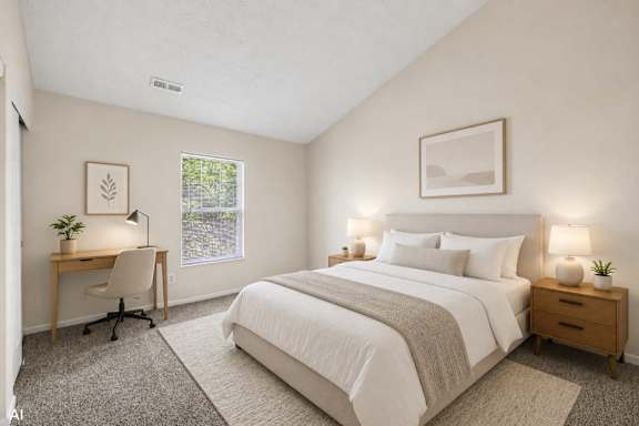 A bedroom with a large bed, a desk with a chair, and two lamps.