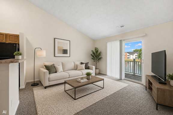 A living room with a white couch, a coffee table, and a television.