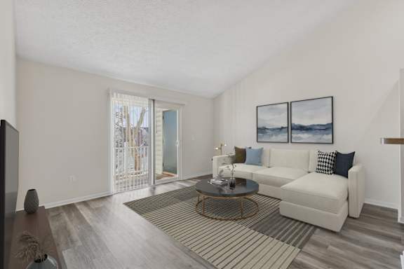 A living room with a white couch and a coffee table.