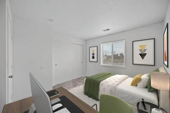 A bedroom with a bed, desk, and chair.