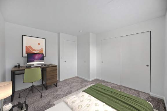 A bedroom with a bed, desk, and chair.