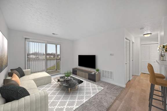 A living room with a grey sofa, a black coffee table, and a television.