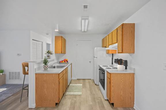 A kitchen with wooden cabinets and white appliances.