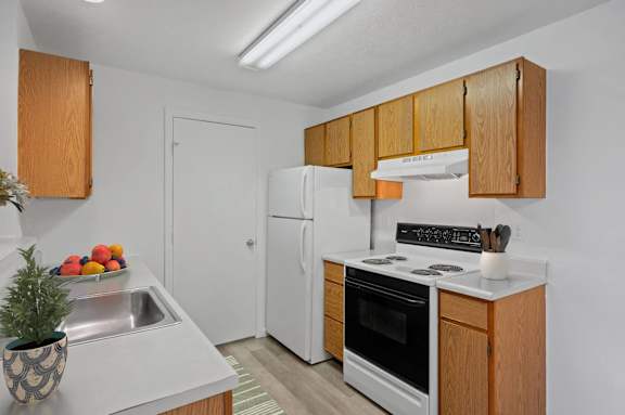 A kitchen with wooden cabinets and a white refrigerator.