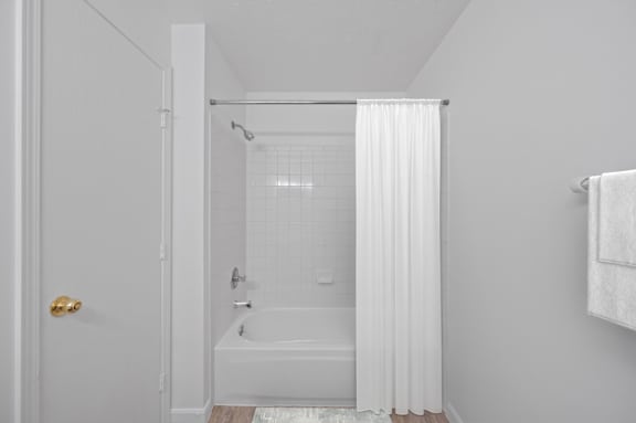 A white bathroom with a tub and shower.