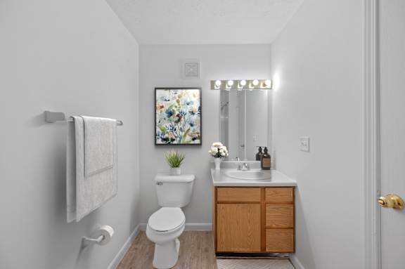 A white toilet sits next to a sink in a small bathroom.