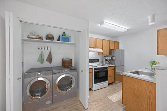 A kitchen with a washer and dryer built into the cabinetry.