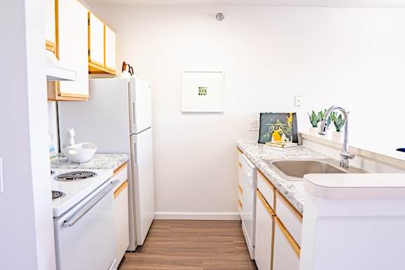 A kitchen with white appliances and wooden cabinets.
