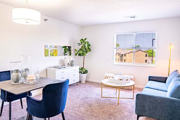 A living room with a blue chair and a grey couch.