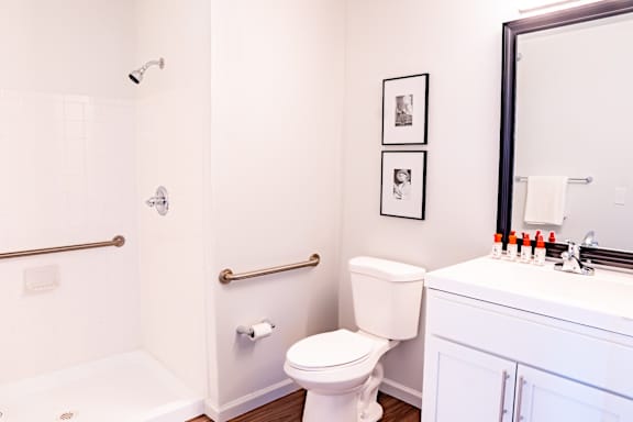 A white toilet in a bathroom with a white tub and a white sink.