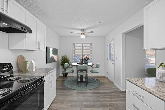 A kitchen with a table and chairs in the middle.