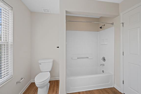 A white toilet is next to a white bathtub in a bathroom.