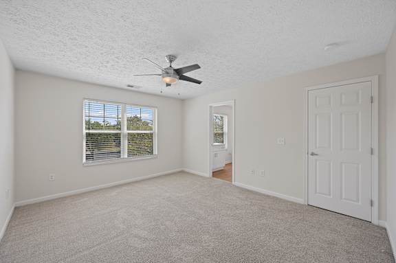 A room with a ceiling fan and a window with blinds.
