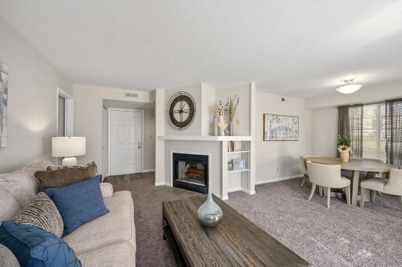a living room with a fireplace and a table and chairs