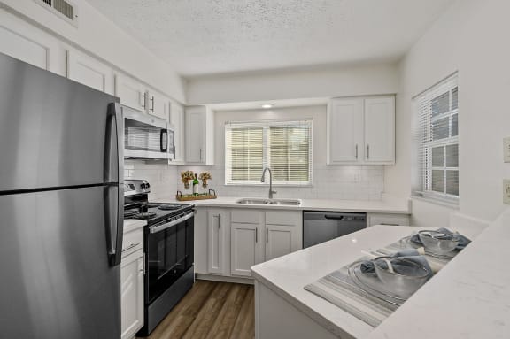 a kitchen with stainless steel appliances and white cabinets