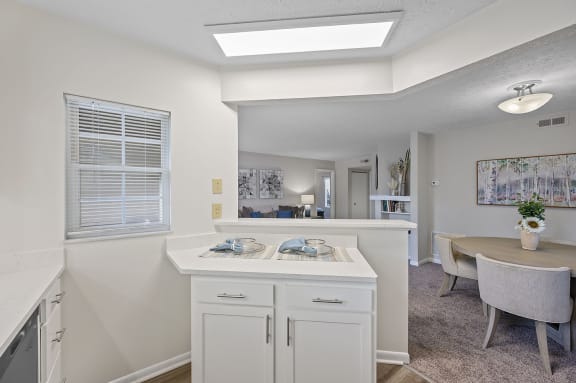 an open kitchen and dining area with a dining table and a window