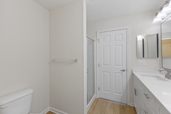 a bathroom with a white door and a white sink and toilet at Four Bridges, Ohio