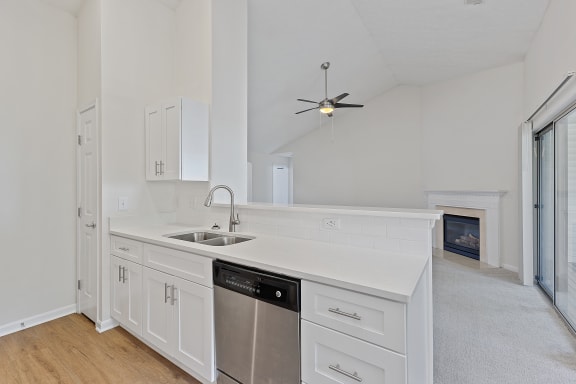 a kitchen with white cabinets and a sink and a ceiling fan at Four Bridges, Liberty Township, OH, 45044-8380