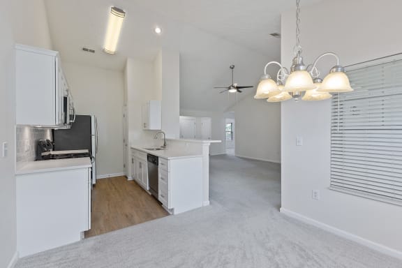 an open kitchen and living room with white cabinets and white appliances at Four Bridges, Liberty Township, Ohio