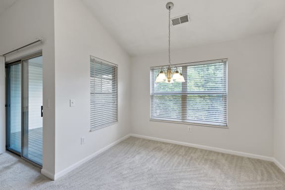 an empty living room with a large window and a door to a bedroom at Four Bridges, Ohio